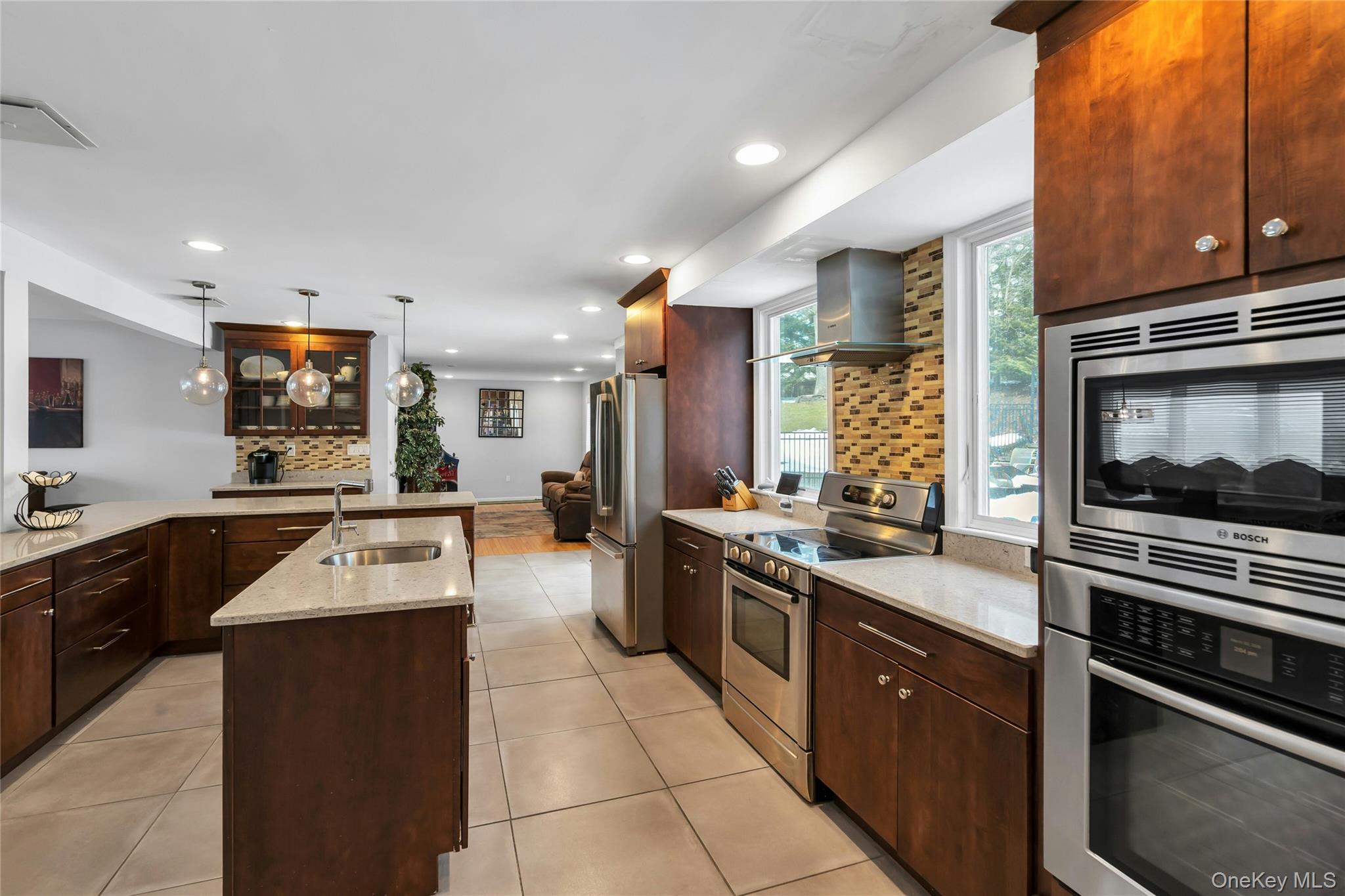 54 Valleywood Road Commack, NY 11725 - Photo 6 of 33 a large kitchen with stainless steel appliances granite countertop a stove top oven a sink dishwasher and cabinets with wooden floor