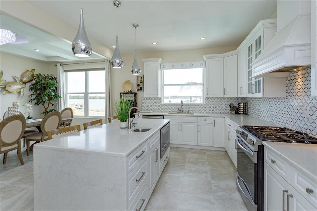 1201 South Riverside Drive Edgewater, FL 32132 - Photo 16 of 47 a kitchen with granite countertop a sink stove and cabinets