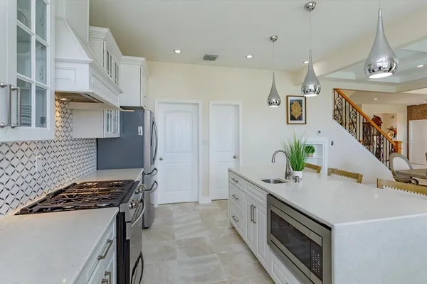 a kitchen with stainless steel appliances granite countertop a sink and a stove