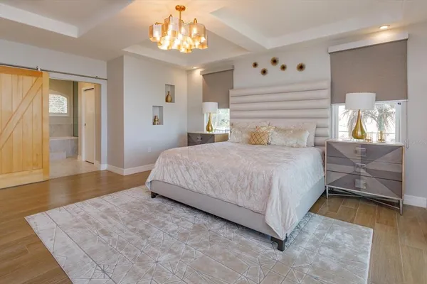 a bedroom with a bed and a chandelier