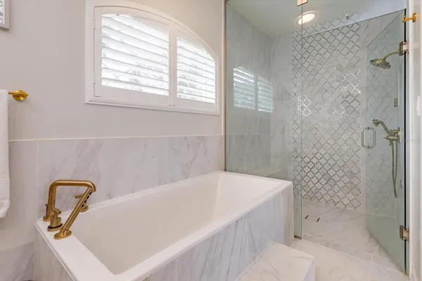 a bathroom with a tub a window and a shower