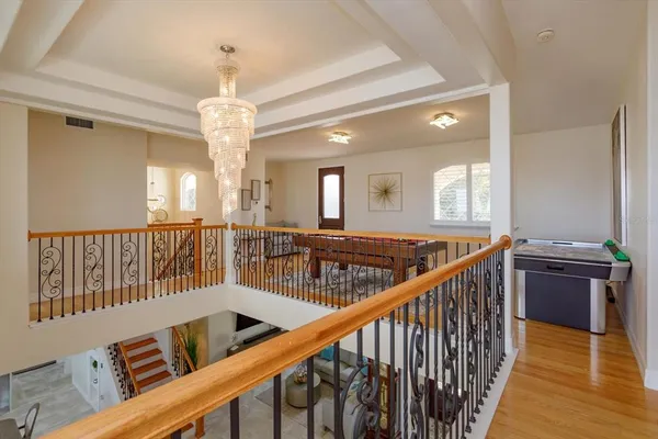 a view of a hallway with wooden floor and staircase