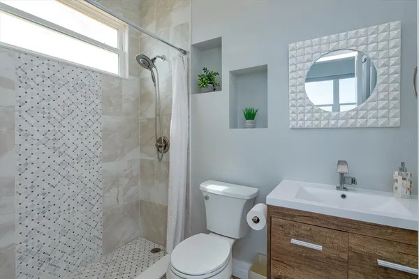 a bathroom with a toilet sink vanity and shower