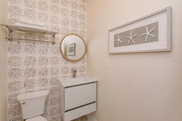 a bathroom with a toilet sink vanity and mirror
