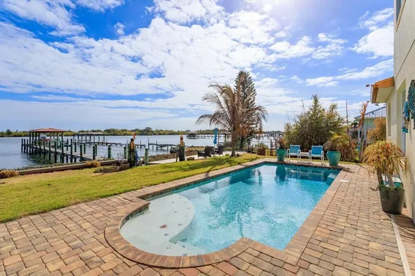 a view of swimming pool with outdoor seating and a lake view