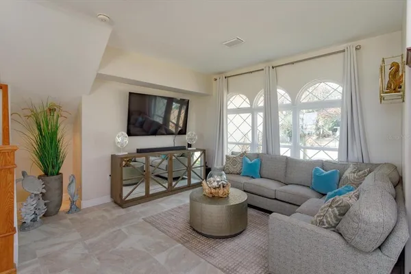 a living room with furniture a flat screen tv and a floor to ceiling window