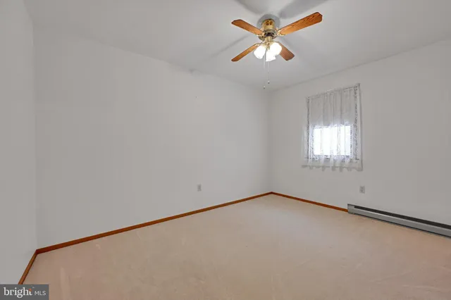 an empty room with a window and a fan