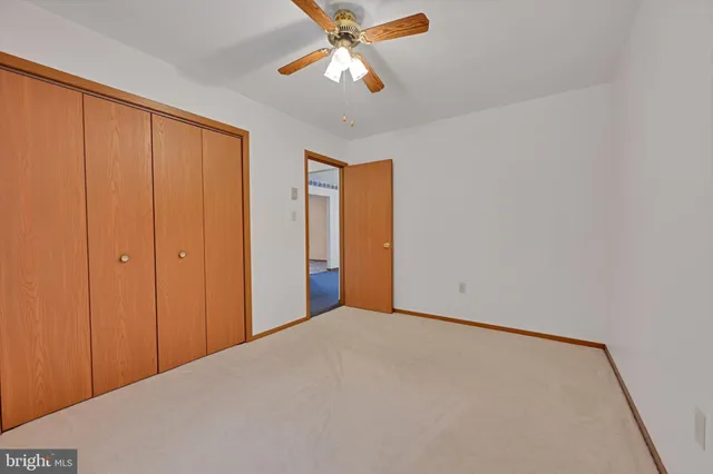a view of an empty room and chandelier fan