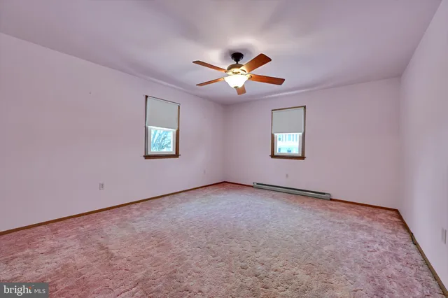 an empty room with a window and a fan