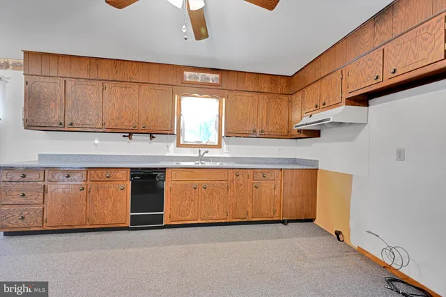 a kitchen with granite countertop cabinets stainless steel appliances and a sink