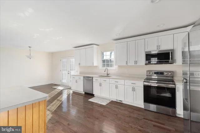 a kitchen with granite countertop a stove top oven sink and cabinets