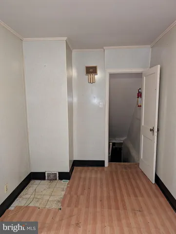 a view of a room with wooden floor and a hallway