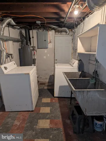 a room with water heater and wooden cabinets