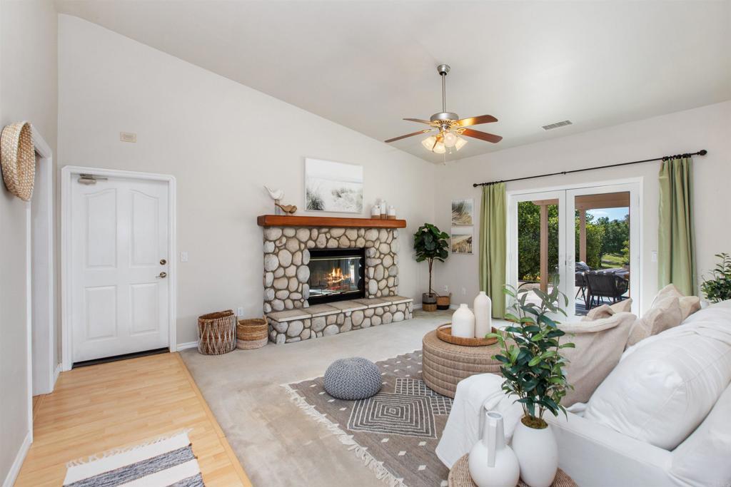 29076 Sunset Road Valley Center, CA 92082 - Photo 23 of 65 a living room with furniture a fireplace and a chandelier
