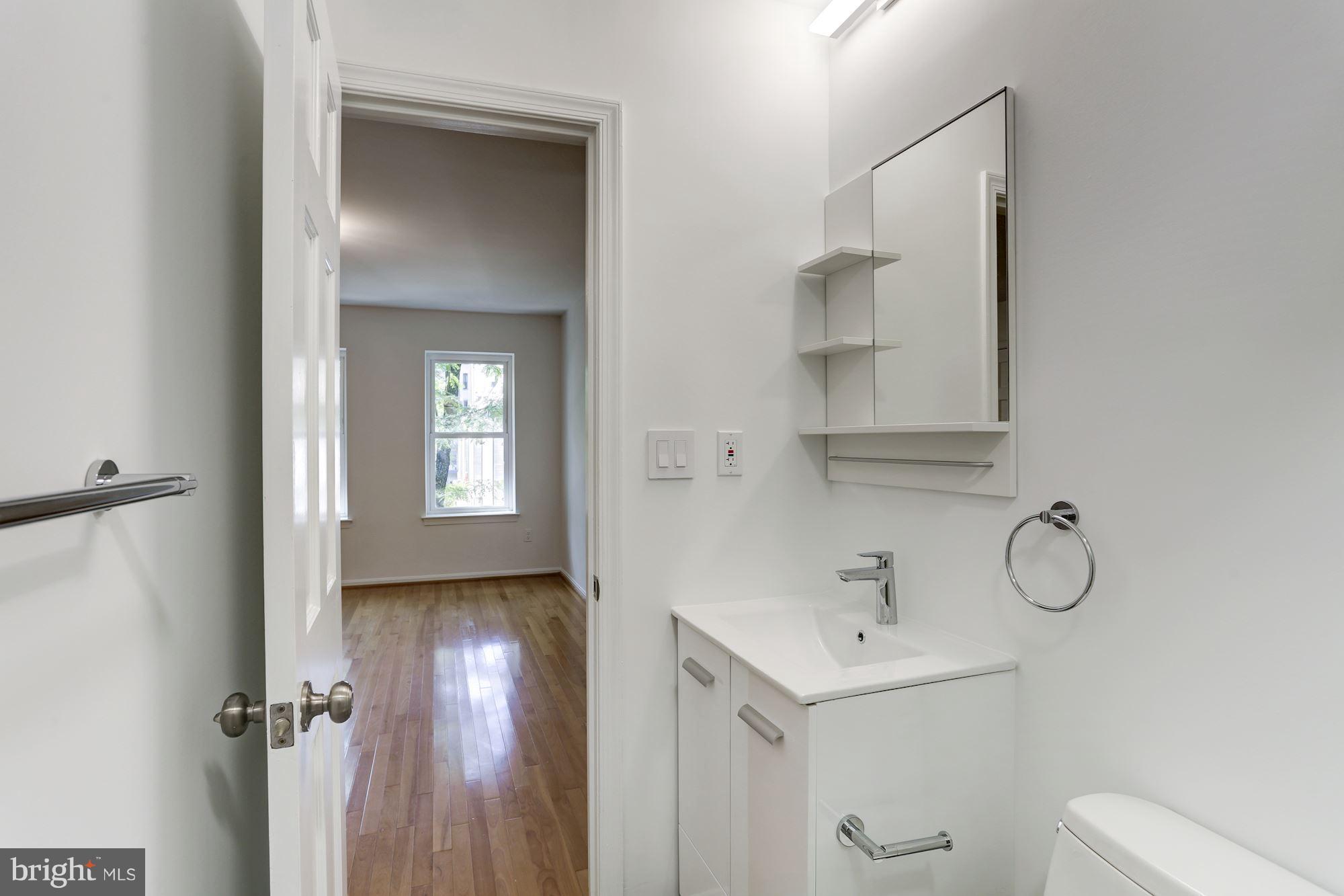 1325 13th Street Northwest, Unit 24 Washington, DC 20005 - Photo 14 of 30 a bathroom with a sink a toilet and a mirror