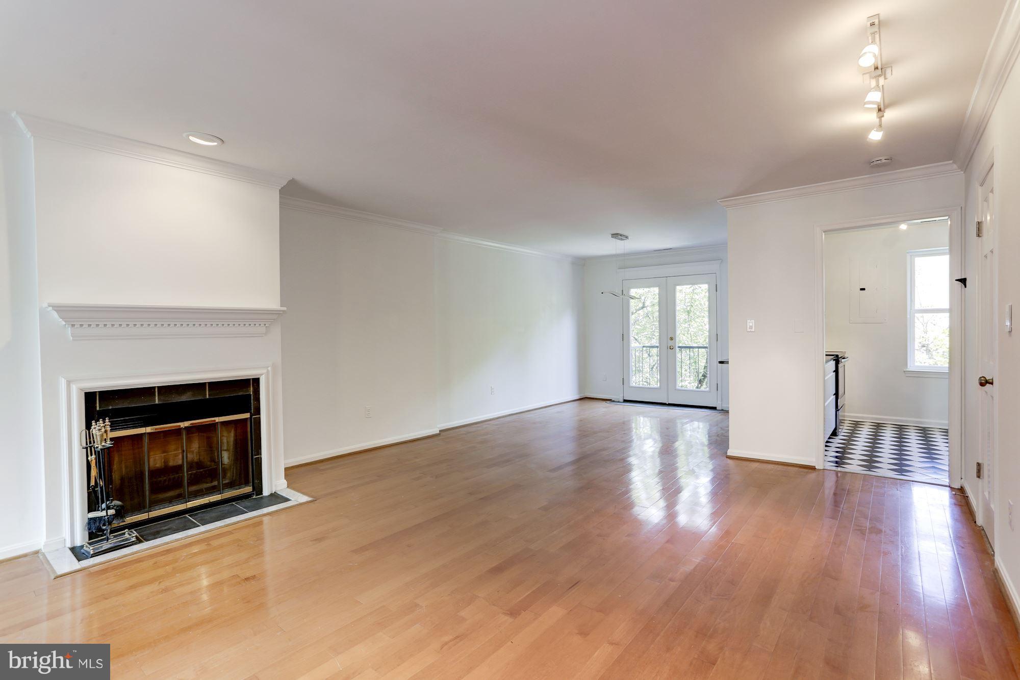 1325 13th Street Northwest, Unit 24 Washington, DC 20005 - Photo 4 of 30 a view of an empty room with wooden floor and fireplace