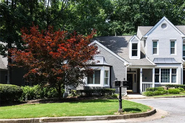 a front view of a house with a yard and trees