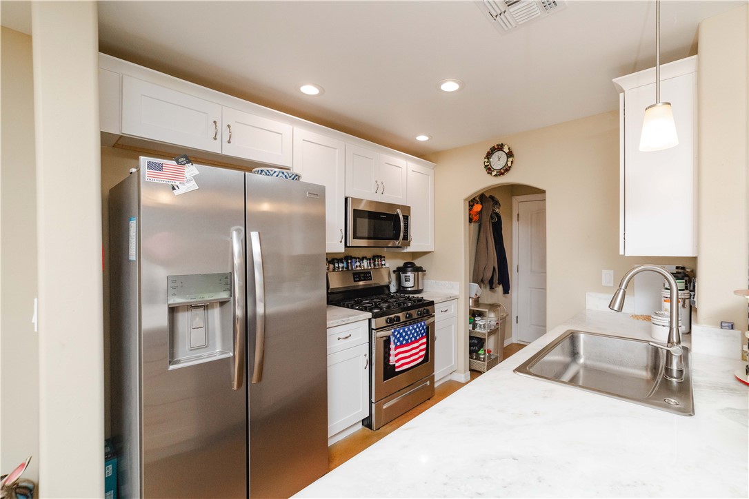 2948 Pinal Road Golden Valley, AZ 86413 - Photo 10 of 59 Kitchen featuring stainless steel appliances, white cabinetry, recessed lighting, a stone-finish countertop, and an undermount sink