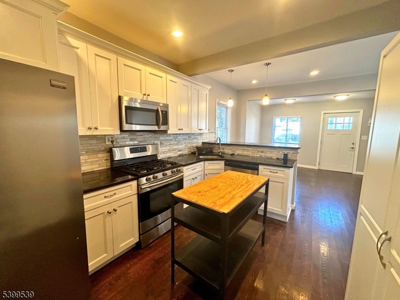 11 Garfield Road Parsippany, NJ 07054 - Photo 3 of 8 a kitchen with stainless steel appliances granite countertop a stove top oven a sink dishwasher and a refrigerator with wooden floor