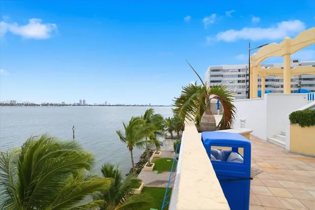 a view of living room with kitchen island stainless steel appliances wooden floor and dining table