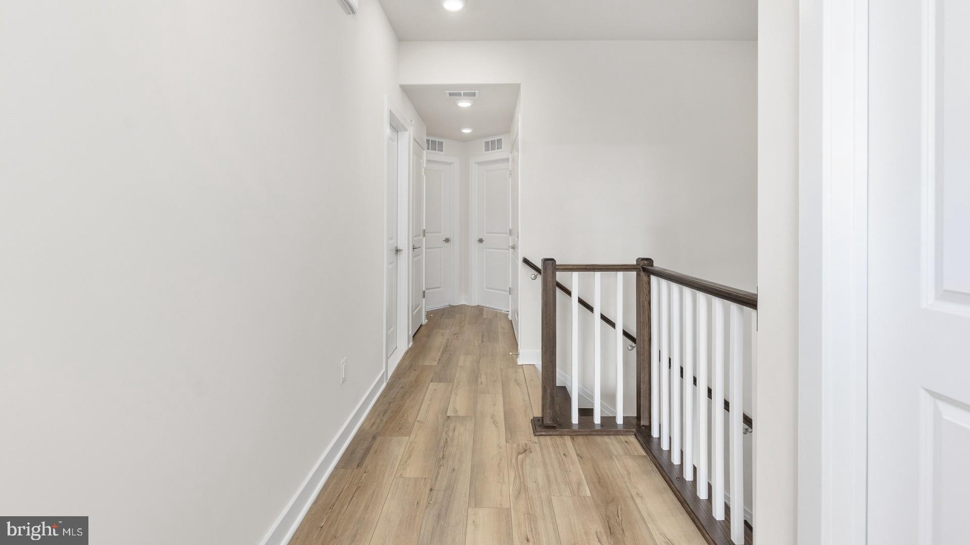 44588 Strabane Terrace Ashburn, VA 20147 - Photo 22 of 26 a view of a hallway with wooden floor and staircase