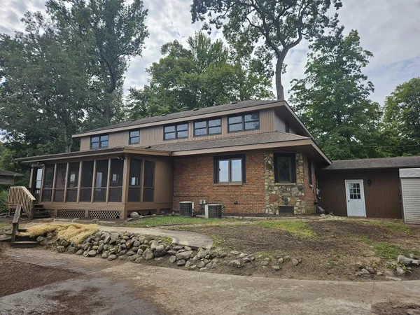 an empty room with wooden floor fireplace and windows