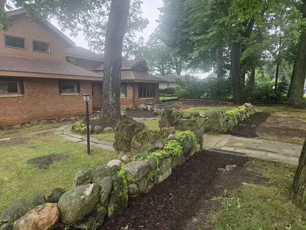 an empty room with wooden floor fireplace and windows