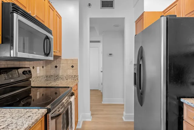 a kitchen with granite countertop a sink a stove and cabinets