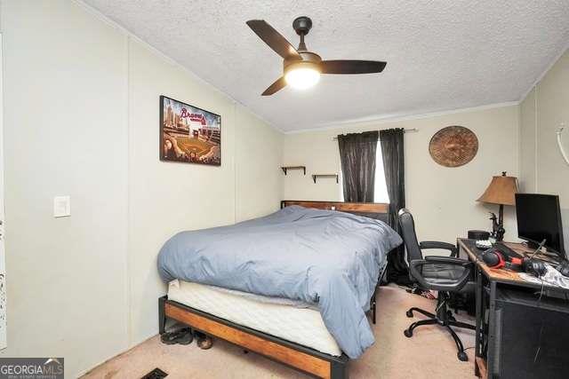 926 Silver Dollar Road Milner, GA 30257 - Photo 12 of 15 a bedroom with a bed and a chandelier