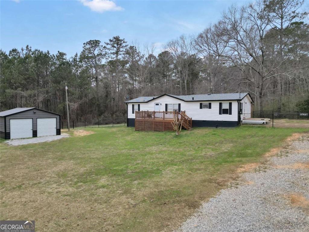 926 Silver Dollar Road Milner, GA 30257 - Photo 2 of 15 a view of a house with a big yard and large trees