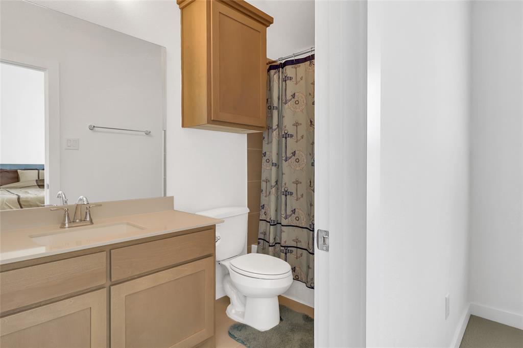 1241 Lupine Road Prosper, TX 75078 - Photo 32 of 38 Bathroom featuring a light-toned vanity with an integrated sink, brushed nickel faucet, and wood-finish cabinetry