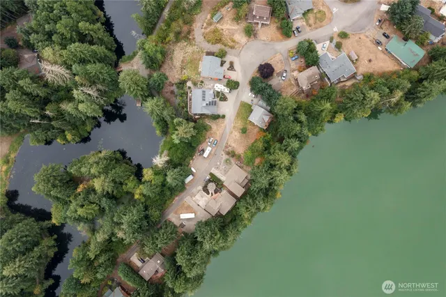 an aerial view of residential house with outdoor space and trees all around