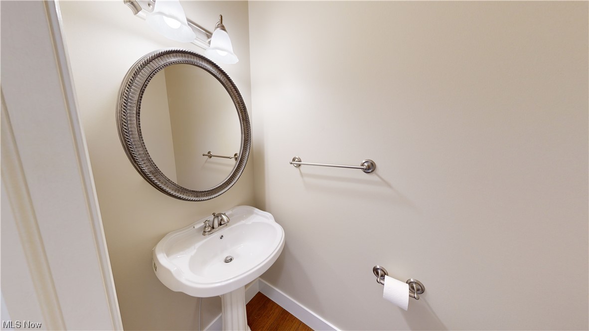 8325 Munson Road Mentor, OH 44060 - Photo 19 of 35 Bathroom featuring wood-type flooring, mirror, and washbasin