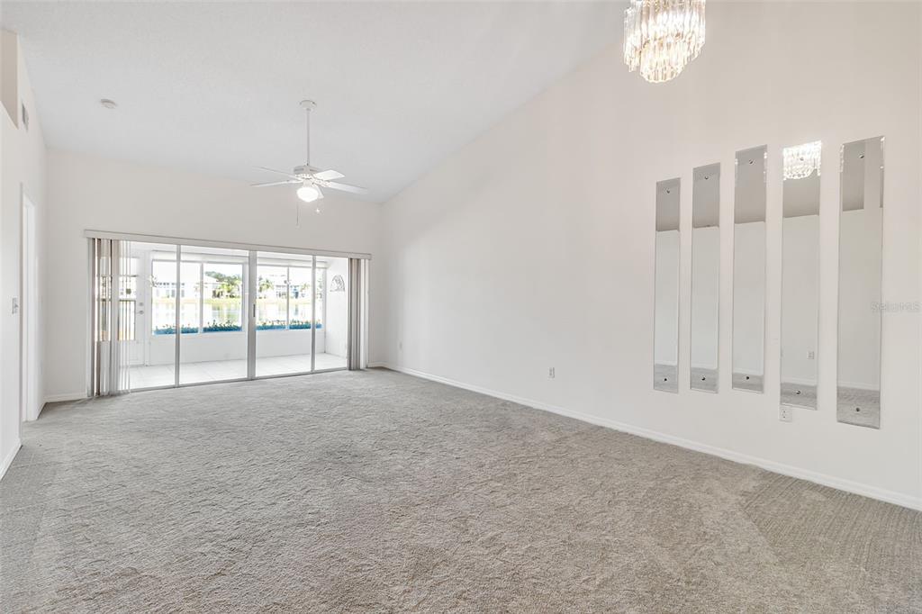 4115 Putter Place, Unit 4115 Bradenton, FL 34203 - Photo 14 of 65 an empty room with windows and chandelier fan