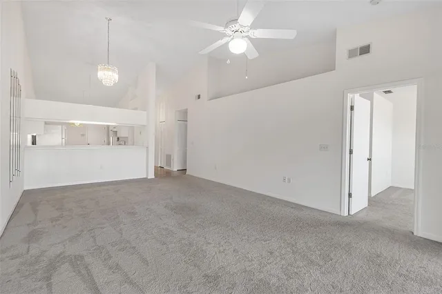 a view of an empty room and window ceiling fan