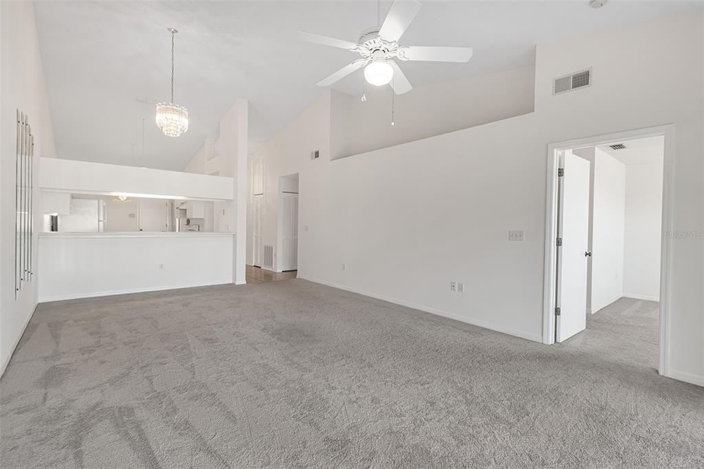 4115 Putter Place, Unit 4115 Bradenton, FL 34203 - Photo 16 of 65 a view of a big room with a ceiling fan and kitchen view