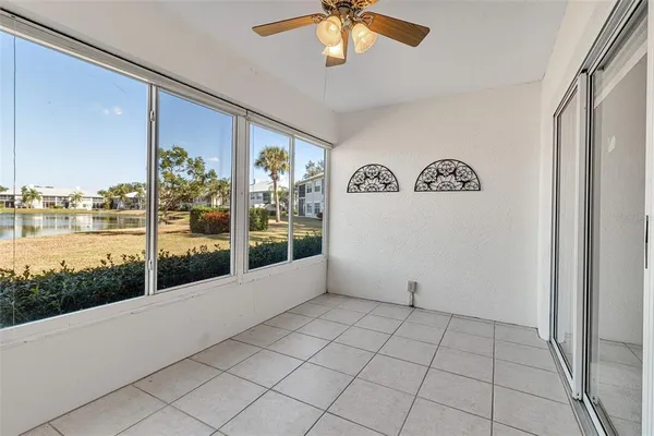 an empty room with a window and a ceiling fan