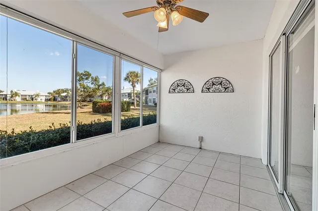 an empty room with a window and a ceiling fan