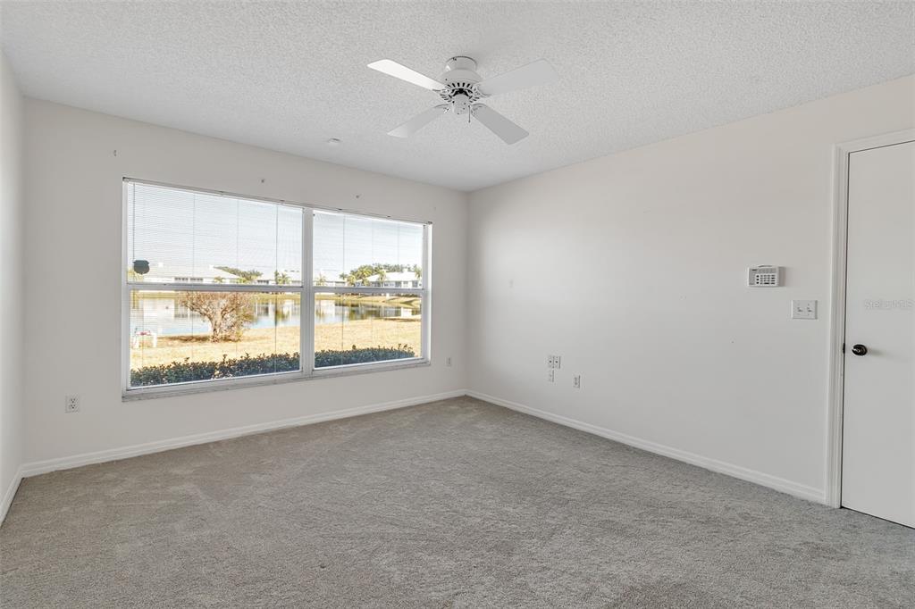 4115 Putter Place, Unit 4115 Bradenton, FL 34203 - Photo 23 of 65 an empty room with a window and a ceiling fan
