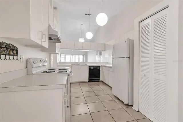 a kitchen with a sink a stove cabinets and refrigerator