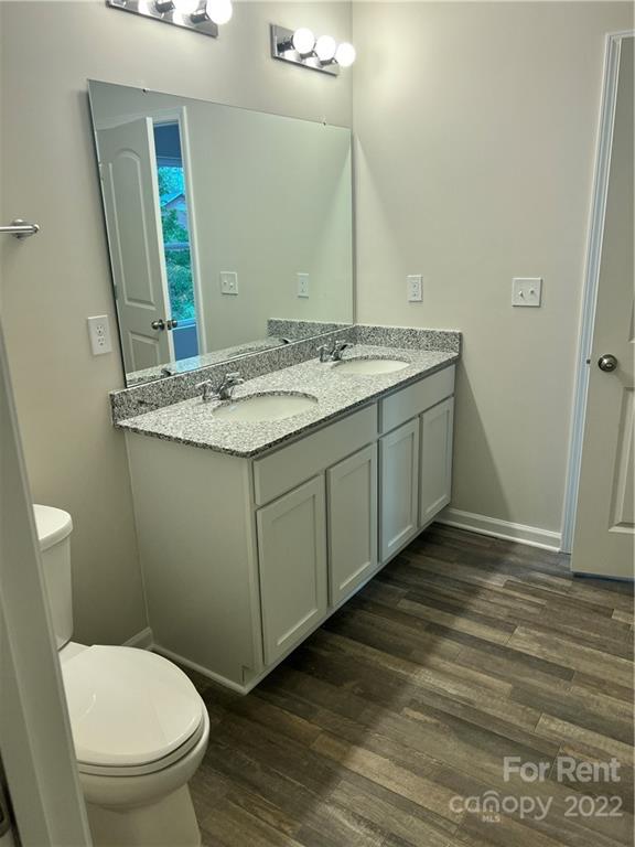 4852 Stone Drive, Unit 127 Conover, NC 28613 - Photo 19 of 34 a bathroom with a granite countertop toilet sink and mirror