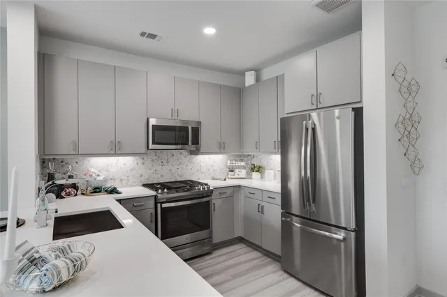 a kitchen with white cabinets and stainless steel appliances