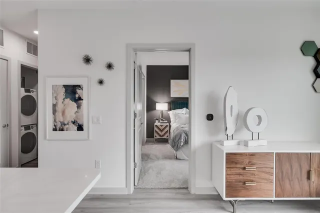 a view of a bedroom with mirror and window