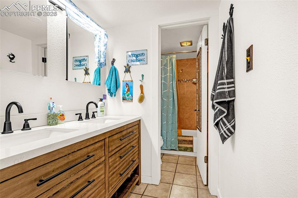 1018 Fontmore Road, Unit C Colorado Springs, CO 80904 - Photo 6 of 33 a bathroom with a sink a mirror and a shower