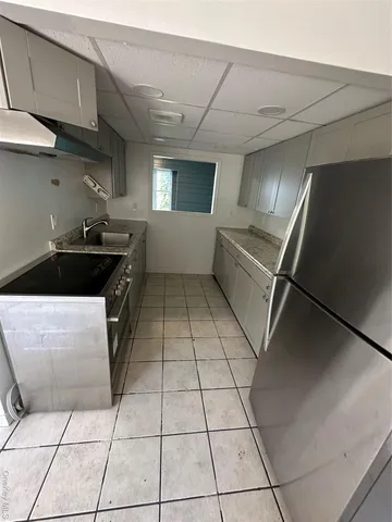 a kitchen with a sink a stove and cabinets