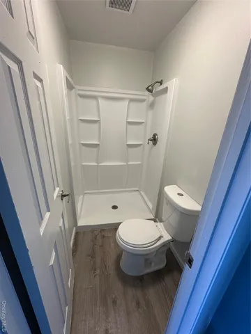 a bathroom with a toilet and a shower