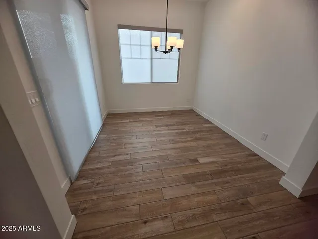 a view of a hallway with wooden floor and a window