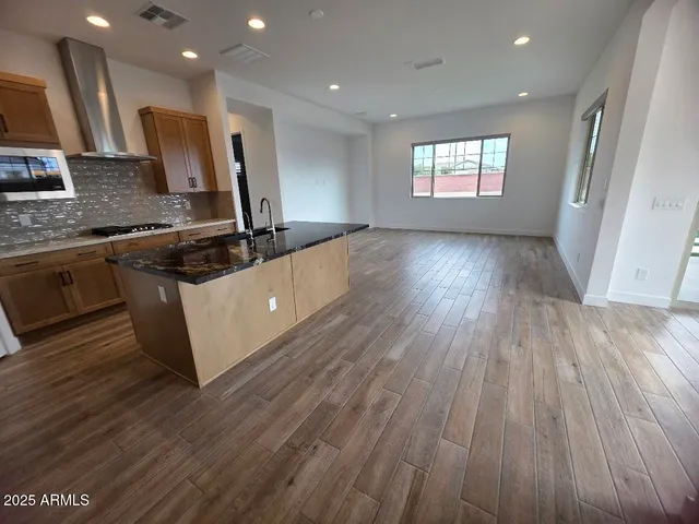 a large kitchen with stainless steel appliances granite countertop a large stove a sink and dishwasher with wooden floor