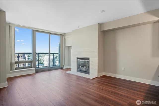 wooden floor fireplace and windows in an empty room