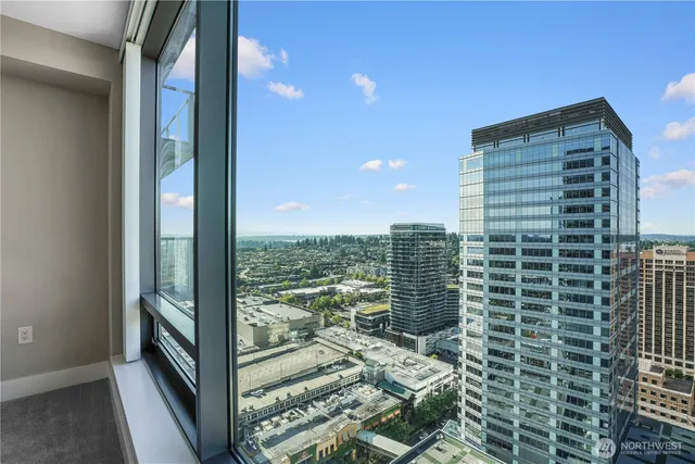 a view of balcony with floor to ceiling window next to a city view